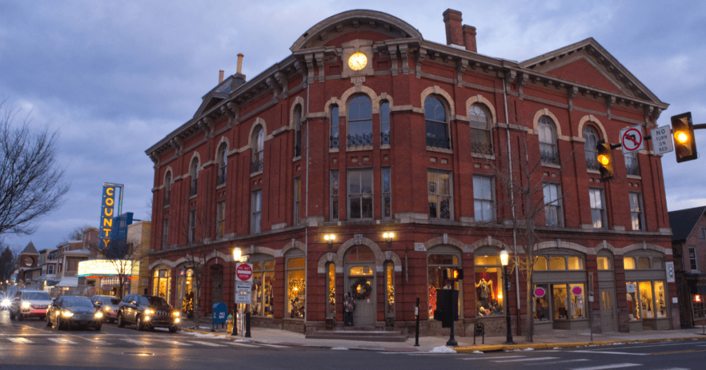 Historic brick buildings at a lit intersection in downtown Doylestown, Pennsylvania, at dusk.