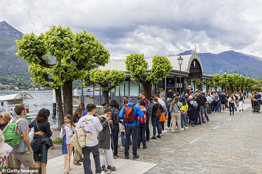 An idyllic Italian beauty spot has been branded 'Gotham City' by its own mayor as he wages war on tourists dining by the lake. Pictured: A crowd of people visit the village of Bellagio from Lake Como