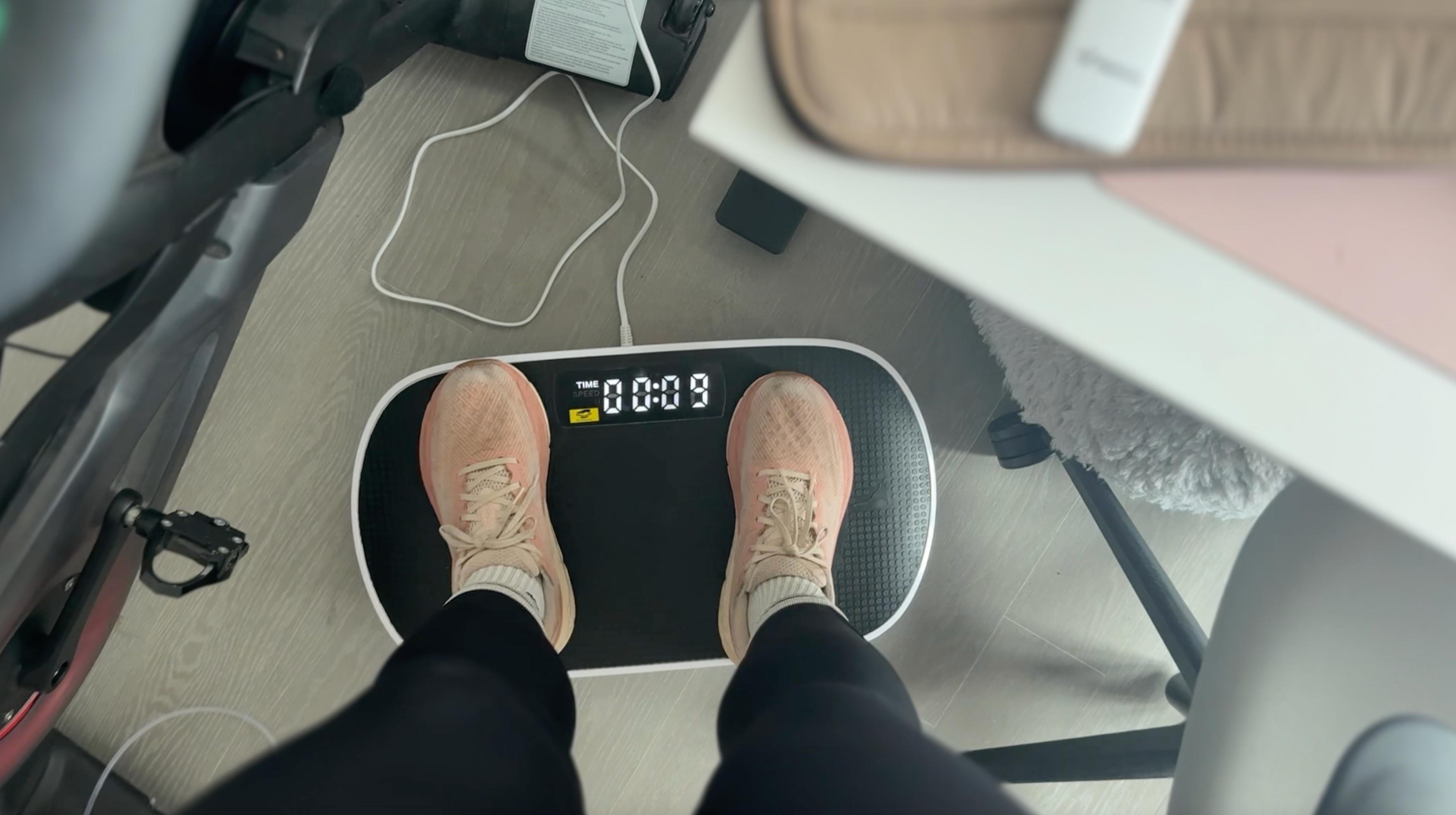 The Independent's Julia Musto stands on a vibration plate in her New York City apartment (Julia Musto/The Independent)