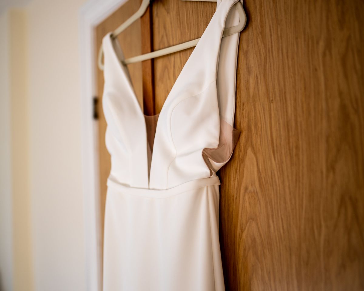 A sleeveless dress with a deep neckline hanging on a wooden chair