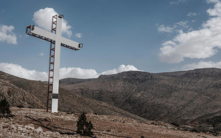 A cross stands above the Christian village of Ras Baalbek - Simon Townsley