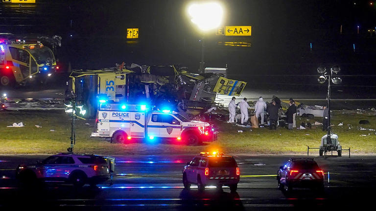 Officials examine the area around an airport firetruck on the runway at LaGuardia Airport after a collision with an Air Canada jet that had just landed, Monday, March 23, 2026, in New York. AP Newsroom © AP Photo/Ryan Murphy