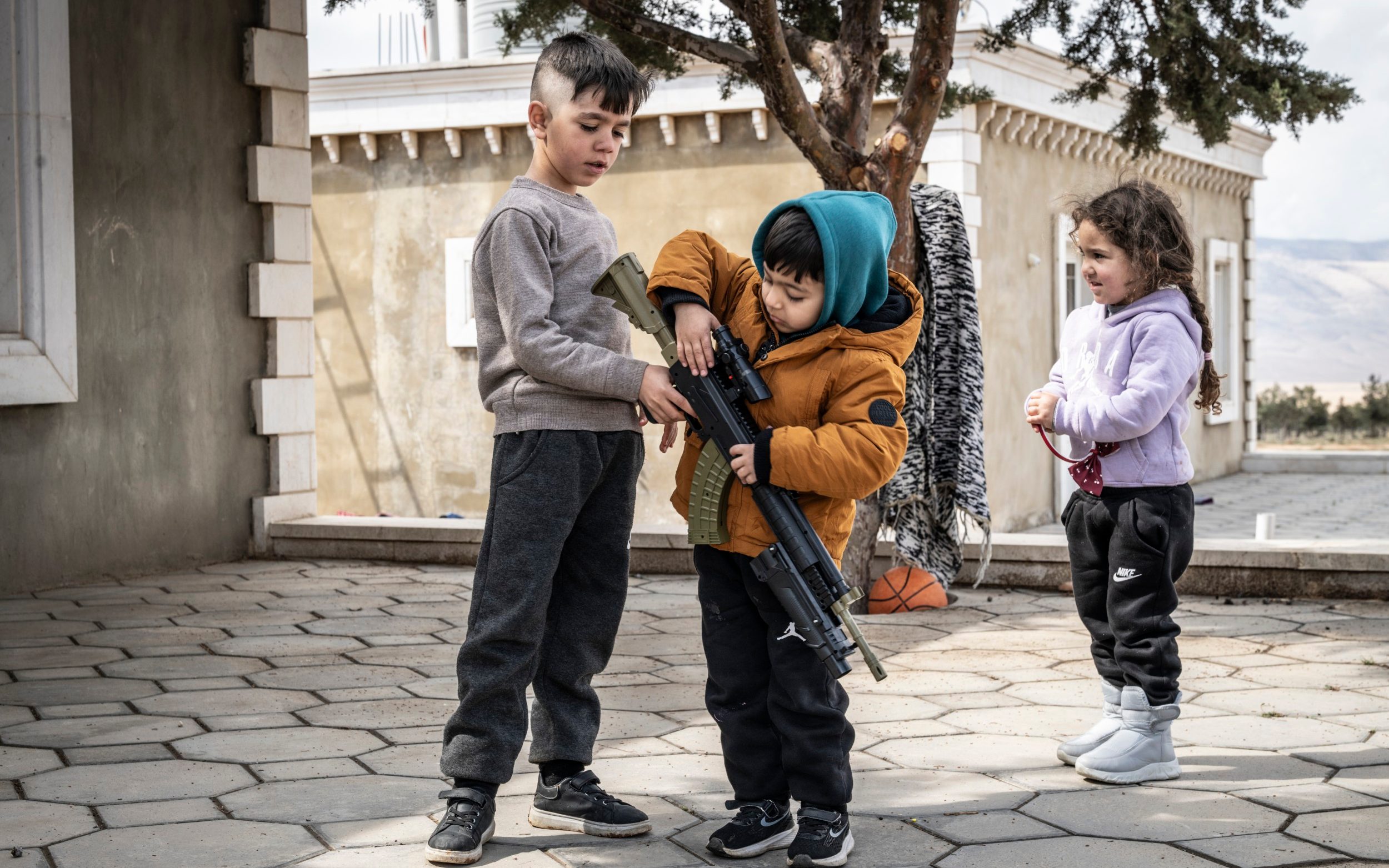 Shia refugees play with a toy gun in the village of Ras Baalbek - Simon Townsley