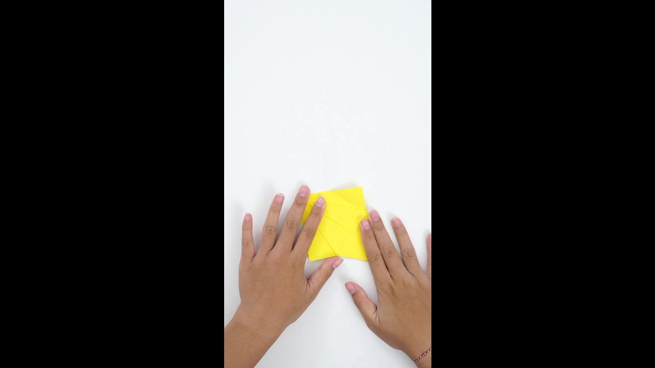 Making a simple yellow paper origami with precise hand folding