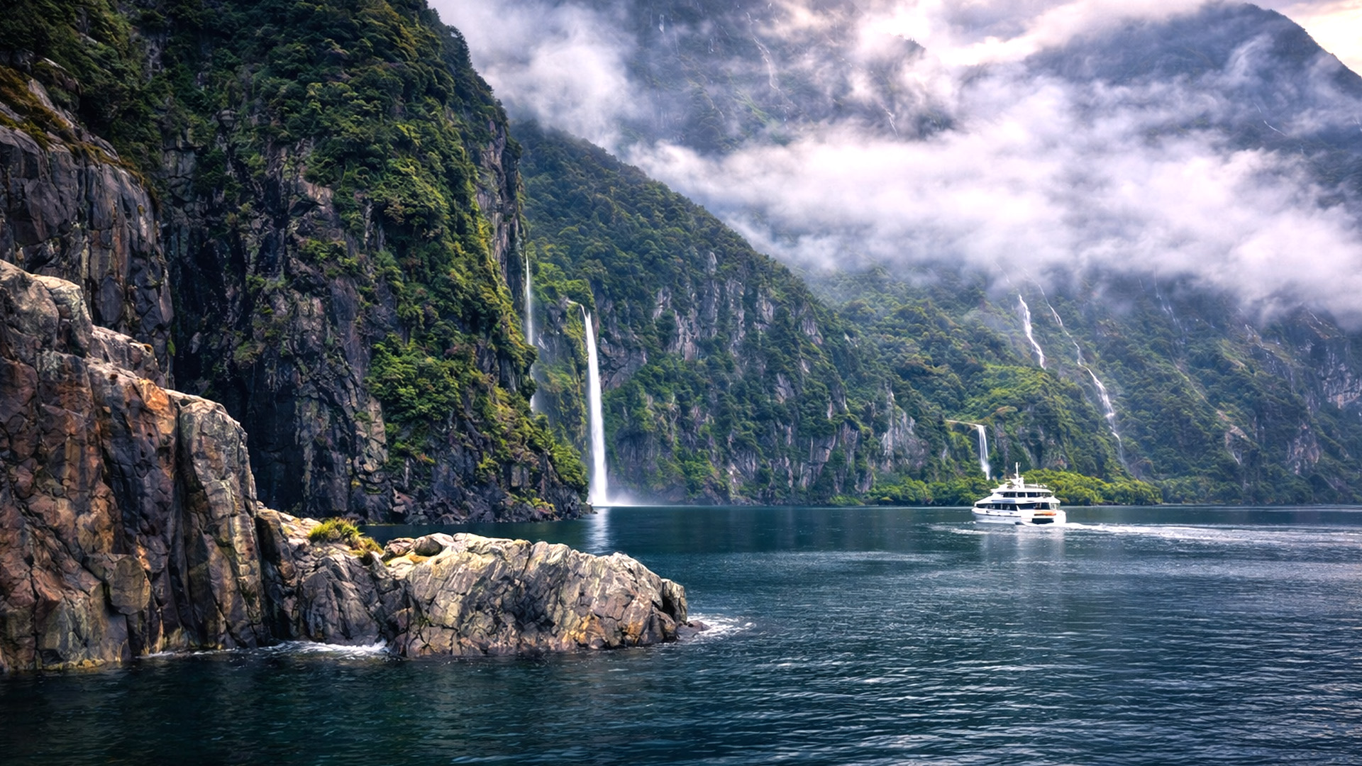 A coastal fjord surrounded by cliffs and waterfalls