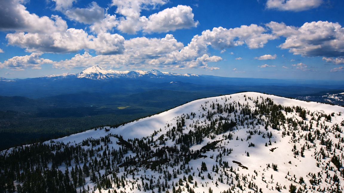 Peaceful snow covered ridge surrounded by vast mountain ranges