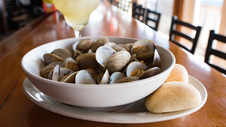 A bowl of clams sits on a bar