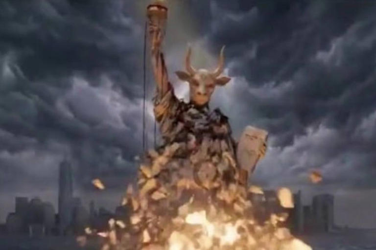 La representación digital muestra una estatua monumental, parecida a la Estatua de la Libertad, envuelta en llamas y parcialmente derruida, con un cielo tormentoso de fondo y estructuras urbanas apenas visibles