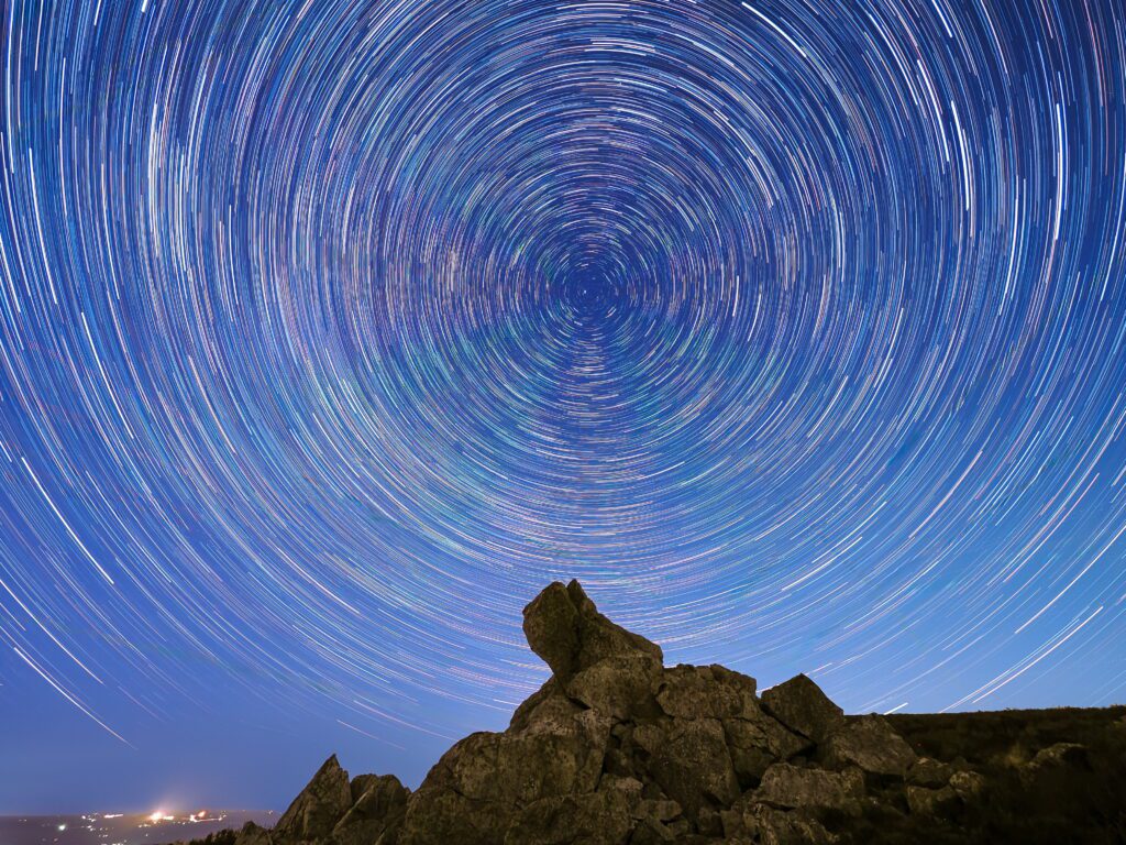 Perfect circular star trails captured above ancient rock formation