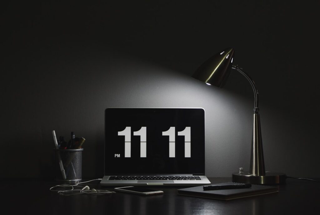 Minimalist dark desk setup with a laptop displaying