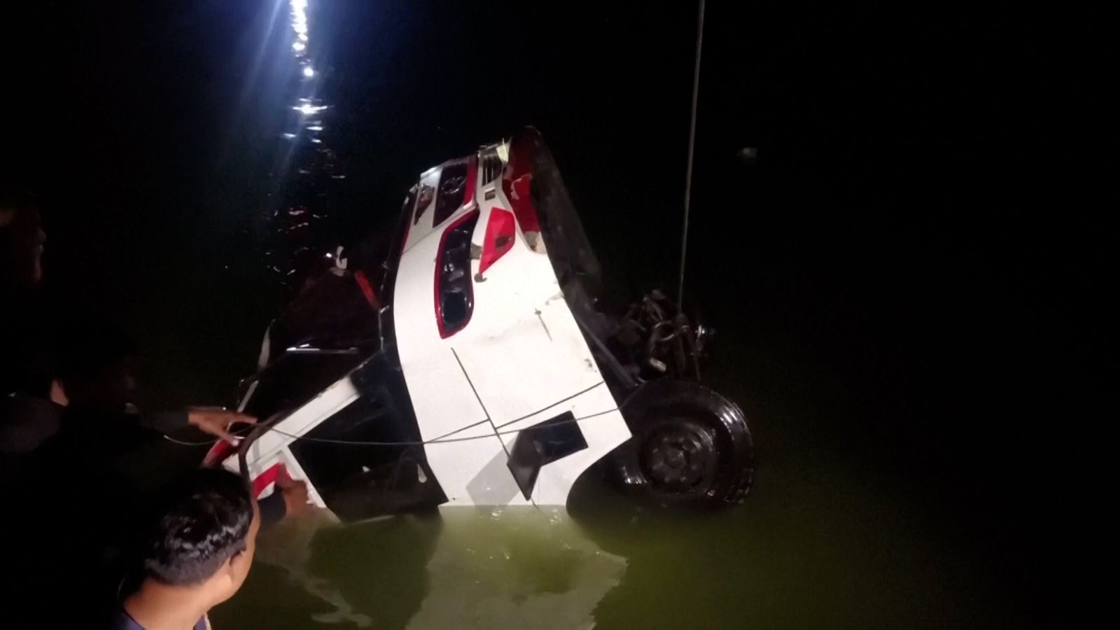 At least 18 dead after bus plunges into river