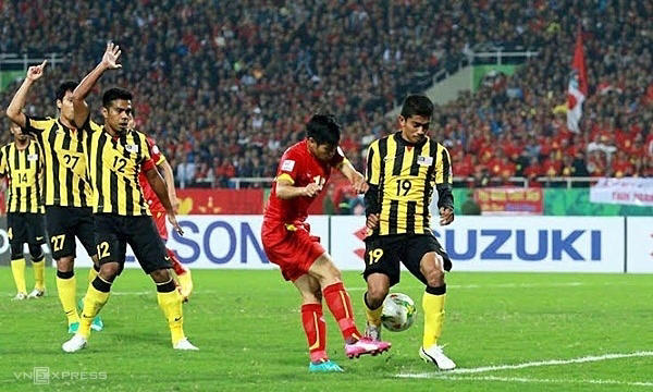 Việt Nam (áo đỏ) trong trận thua Malaysia 2-4 trên sân Mỹ Đình, Hà Nội ở lượt về bán kết AFF Cup tối 11/12/2014. Ảnh: Lâm Thỏa