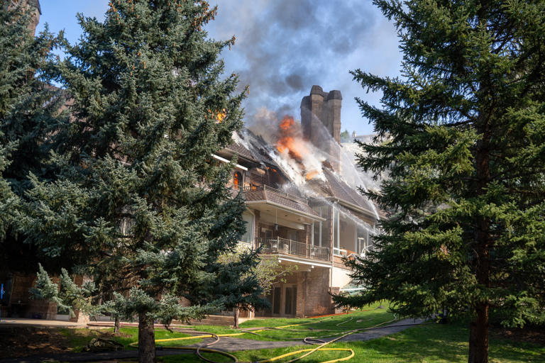 Firefighters battle house fire in Sandy, smoke and flames visible