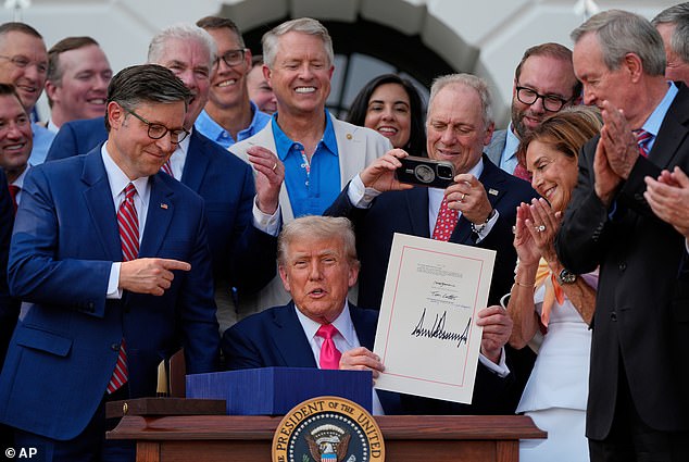 President Donald Trump will become the first-ever US president to have his signature appear on every single dollar. He is pictured holding up his signed signature bill of tax breaks and spending cuts at the White House last year