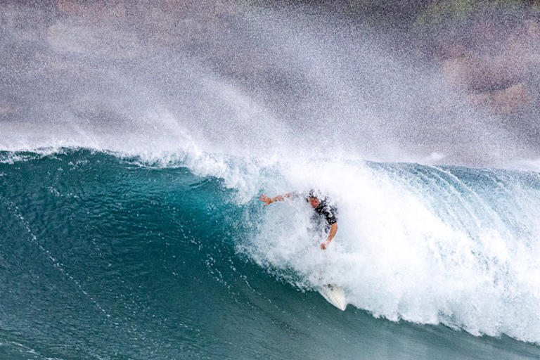 A surfer takes on the growing swell at Maroubra.