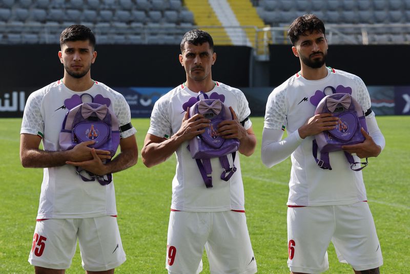 Soccer Football - International Friendly - Iran v Nigeria - Mardan Sports Complex, Antalya, Turkey - March 27, 2026 Iran's Aria Yousefi, Ali Nemati and Mohammad Ghorbani hold school bags in memory of the victims of the girls school bombing in Minab, Iran REUTERS/Umit Bektas