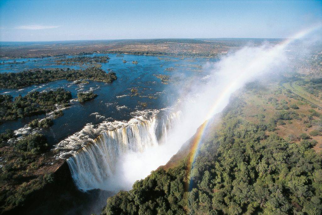 <p>Victoria Falls, otherwise known as "The Smoke That Thunders," is one of the most famous waterfalls in the world. It can be found on the Zambezi River on the border between Zambia and Zimbabwe and has a width of over 5,604 feet.</p> <p>While seeing Victoria Falls from the ground is still a great experience, seeing it from a helicopter makes it even more special. From the sky people can view the rainbow shining through the waterfall's mist. Some tours get to ride above the Batoka Gorges and Zambezi National Park where people can spot giraffes, crocodiles, hippos, and elephants.</p>