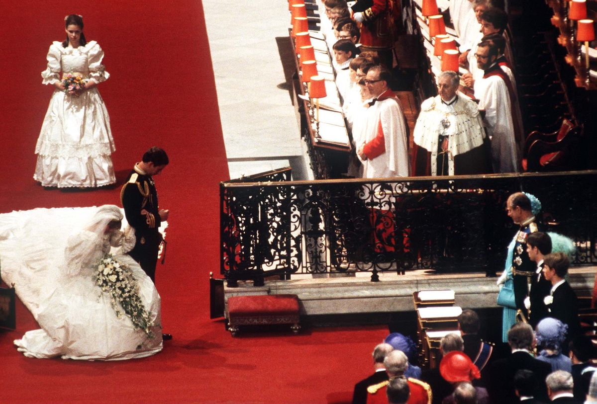 <p>Walking down the aisle on her wedding day, Princess Diana dips into a deep curtsy before Queen Elizabeth while then-Prince Charles lowers his head into a bow.</p>