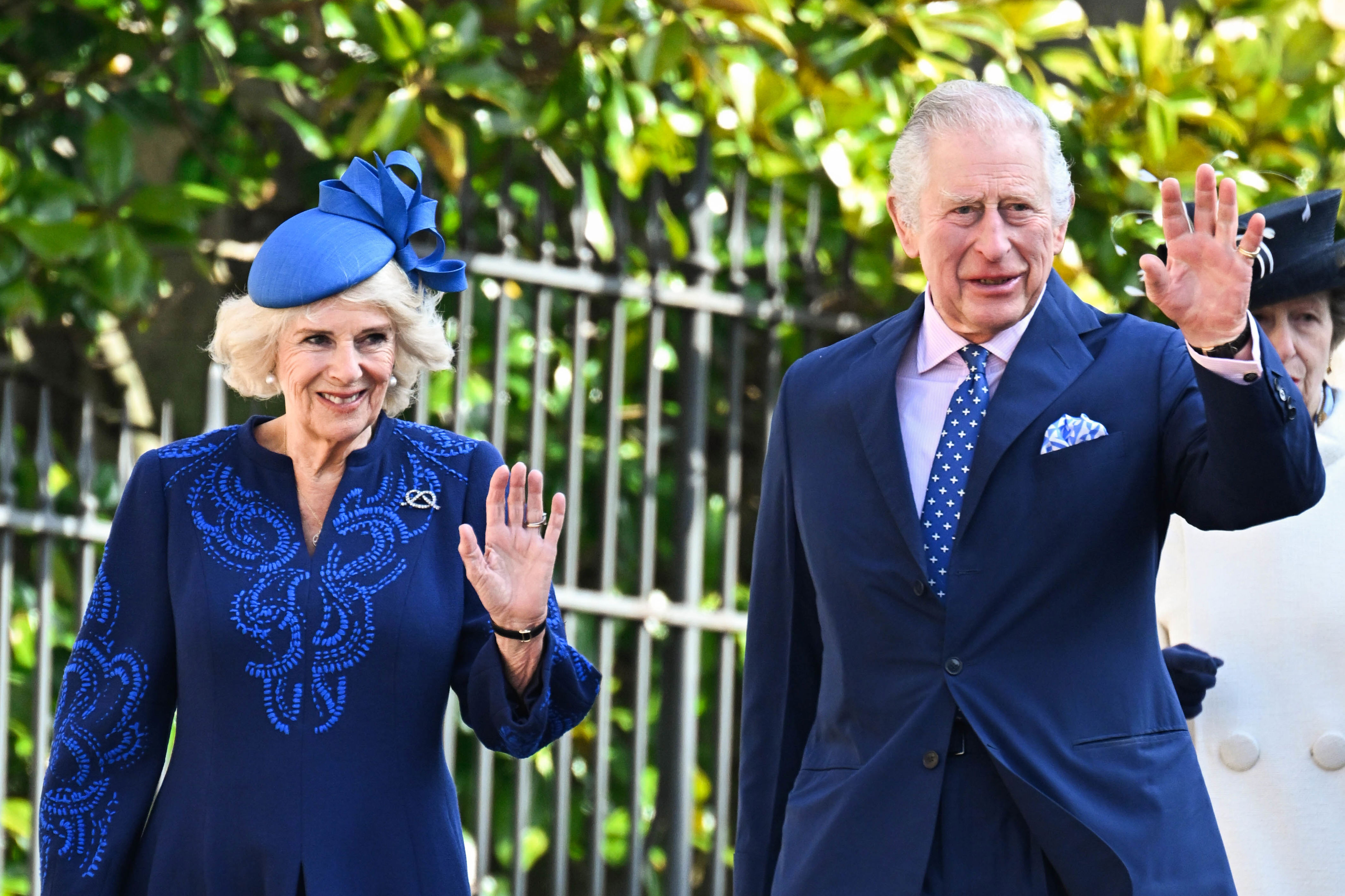 <p>Queen Consort Camilla and King Charles III, who coordinated in royal blue ensembles, waved on their way to the Easter Mattins Service at St. George's Chapel at Windsor Castle in England on April 9, 2023.</p>