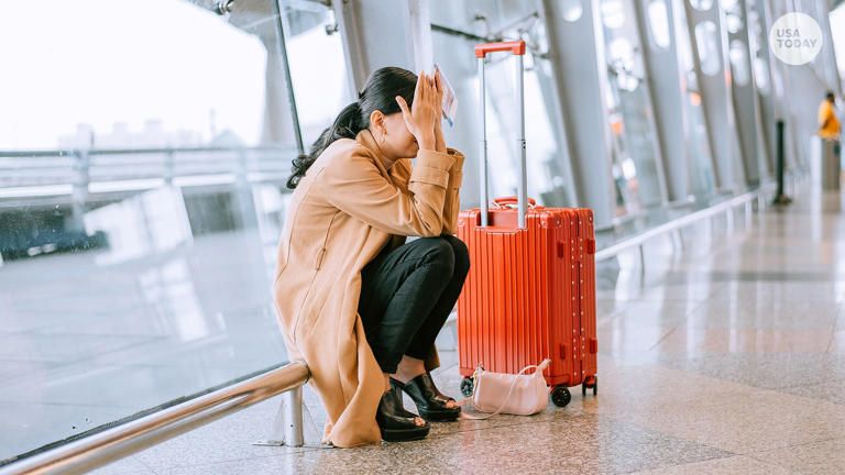 Young Asian businesswoman sad and unhappy at the airport with flight canceled.