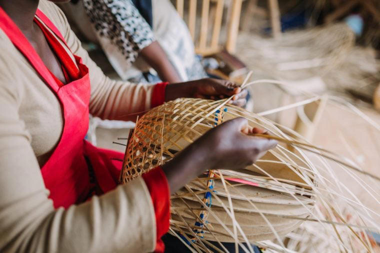 woman weaving a basket out of bamboo in Rwanda Africa