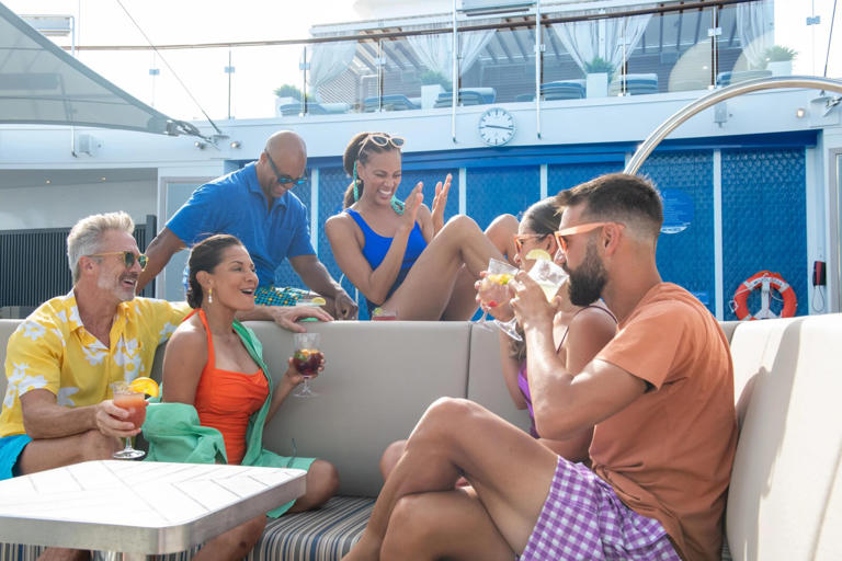 Six adults, drinking and laughing, at the Serenity Adult-Only Retreat on Carnival Cruise Line's Mardi Gras.