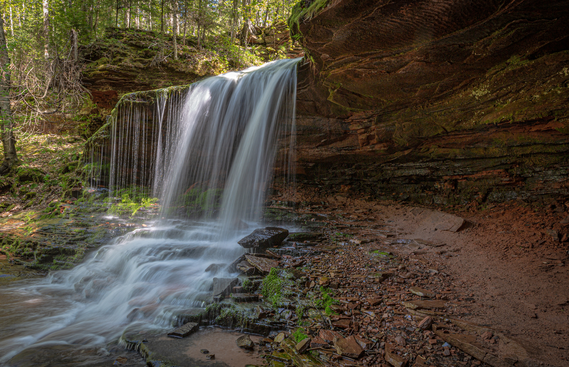 <p class="p1"><span>Those who are adventurous enough to travel off the beaten path to find this secluded spot will be rewarded with one of the most peaceful waterfalls in the entire country (be sure to get a picture standing between the rocks and the rushing water). <a href="https://www.travelwisconsin.com/natural-attractions-and-parks/lost-creek-falls-254404" rel="noreferrer noopener"><span>Lost Creek Falls</span></a> is located near Cornucopia on the Bayfield peninsula. </span></p>