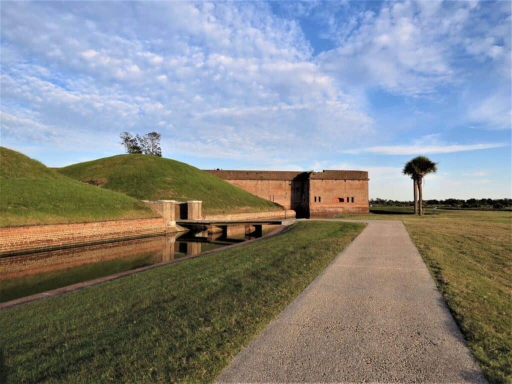 <p class="has-text-align-left"><em>Recommended by Alison of ExplorationSolo.com</em></p> <p>Built in 1847 to protect Savannah's waterway, Fort Pulaski played a pivotal role in the Civil War. In a key battle, Union forces overtook the fort in 1862, crippling the Southern supply chain.</p> <p>Now a National Monument just 15 miles from downtown Savannah, it's <a href="https://explorationsolo.com/exploring-savannah-as-a-solo-traveler/" rel="noopener">a great place to visit</a> and spend a few hours and perfectly safe for solo travelers visiting the Savannah area.</p> <p>Even if you're not a history buff, the beautiful red brick fort on Cockspur Island has a park-like setting. Green grass, palm trees, and blue water greet you upon entering.</p> <p>You can explore the fort, see how the soldiers lived, and get an up-close view of the artillery they used. Around the exterior is evidence of the battle with damage from cannon fire.</p> <p>Beyond Fort Pulaski, Cockspur Island offers four walking trails. Most guests enjoy the Lighthouse Overlook Trail for views of the Cockspur Island Lighthouse.</p> <p>For those more adventurous, try the two-mile Historic Dike System Trail, which circles Fort Pulaski. As you enjoy views of the Island and Savannah River, you'll also encounter sandy beaches and areas to stop for a picnic lunch.</p> <p>You can easily spend half a day at Fort Pulaski, and $10 per person, it's a good deal. If you need more time, your ticket is good for seven consecutive days. It's a perfect way to get away from the crowds and see a piece of history.</p>
