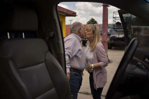 Bobby Gutierrez, the mayor of Bryan, Tex., gives his wife a kiss before getting in his car.