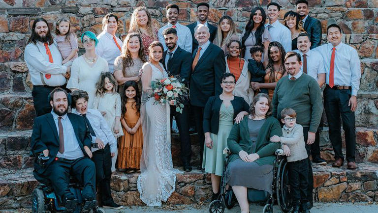 Holly Richardson poses with 15 of her children and their families at her daughter’s wedding. Four of Holly’s children and two of her grandchildren are not in the photo.