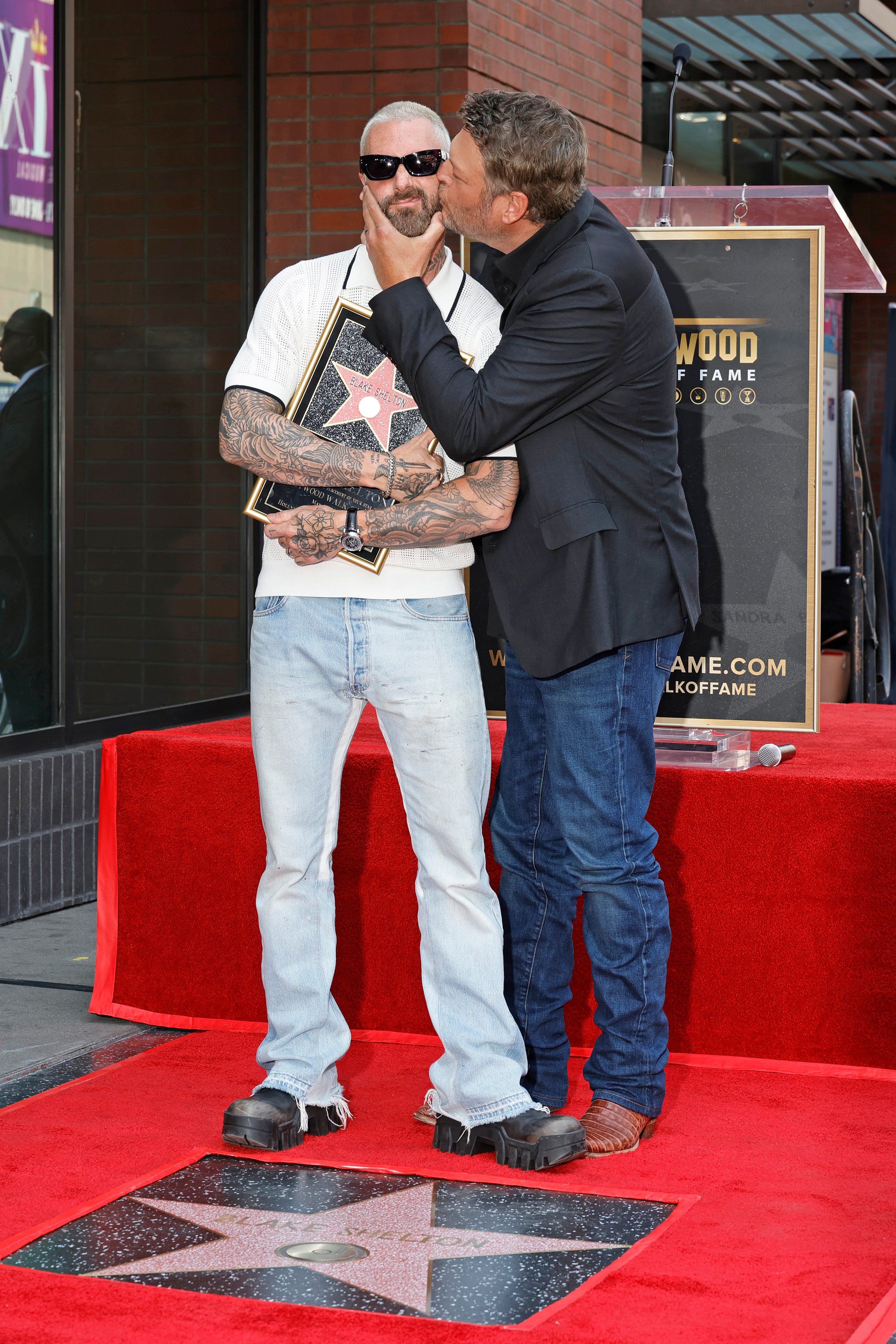 Shelton planted a big fat kiss on his former "The Voice" companion Adam Levine's cheek for a funny moment during the day.