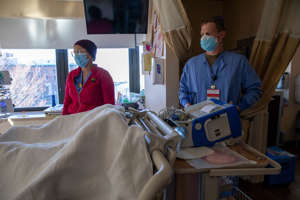 U.S. Army Sgt. Brandyn Laughlin, right, a respiratory therapist assigned to 14th Field Hospital, shadows Marlyn Frias, left, a registered nurse at Lifespan Community Health Institute during the COVID response operations at the hospital in Providence on Jan. 21, 2022.