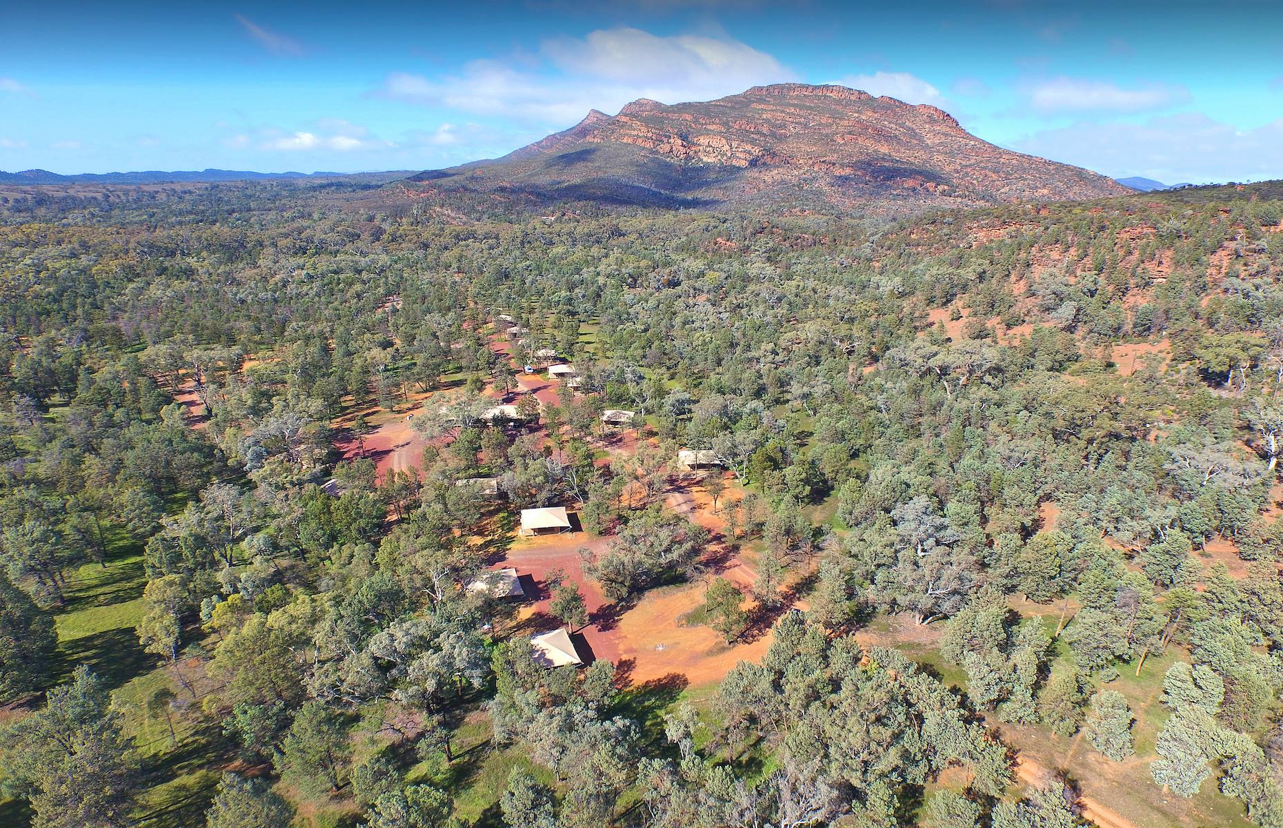 <p>When it comes to location, it’s hard to beat the setting of <a href="https://www.wilpenapound.com.au/accommodation/ikara-safari-camp/">Ikara Safari Camp</a>. With the majestic natural amphitheater of Wilpena Pound looming right above, the occupants of the 15 tents of Wilpena Pound Resort's glam outback outpost have sensational views. The fan-cooled tents mostly sleep two with a couple of family-sized ones sleeping four. The emphasis at the camp, which is part-owned by Indigenous Business Australia and traditional land owners, the Adnyamathanha, is on eco-conscious exploration and utter immersion in the ancient landscape. </p>