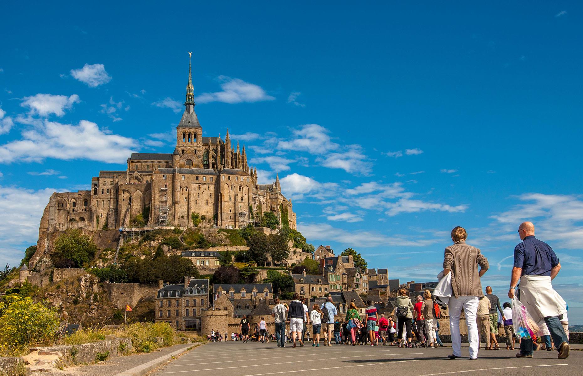 <p>In an unusual twist to deter visitor numbers to one of its top attractions, local authorities in Normandy, France have posted images of endless queues (like the one pictured) to stop more tourists from coming. Mont St Michel, a famous 10th-century abbey, has attracted 60,000 visitors in one weekend (late May 2023), forcing those in charge to declare that the site could no longer handle peak-time crowds.</p>