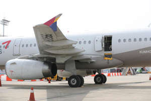 An Asiana Airlines plane is parked after an emergency landing at Daegu International Airport on Friday with its door left open after a passenger opened it during the flight. Photo by Yonhap