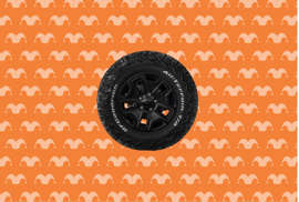 A car tire on top of an orange background covered in jester caps