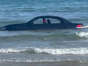 A convertible BMW washed out to sea after being parked on a beach