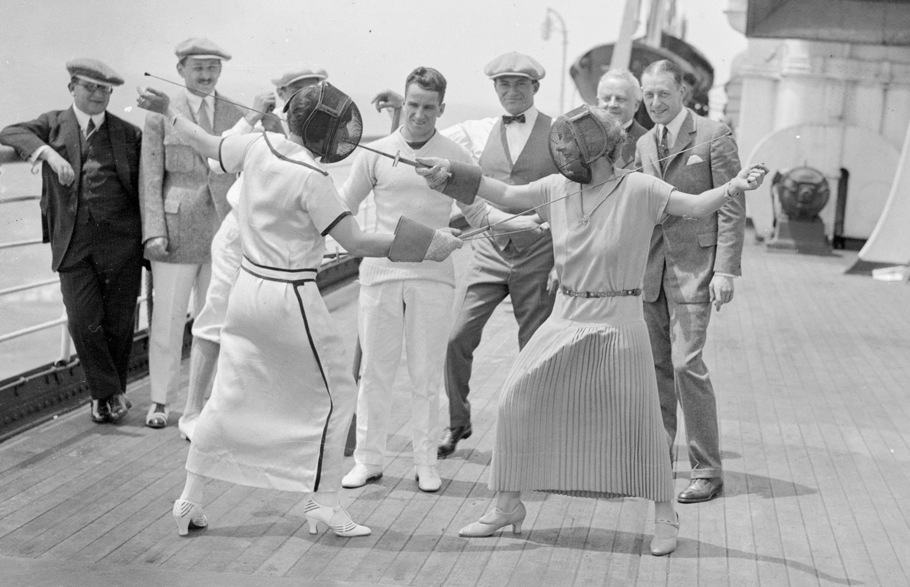 In the Roaring Twenties, onboard entertainment was still focused around fun deck games and sports. Here spectators look on in delight as a pair of women take part in a fencing duel aboard Cunard's Berengaria (formerly Hamburg America Line's Imperator). The shot was taken in 1923.