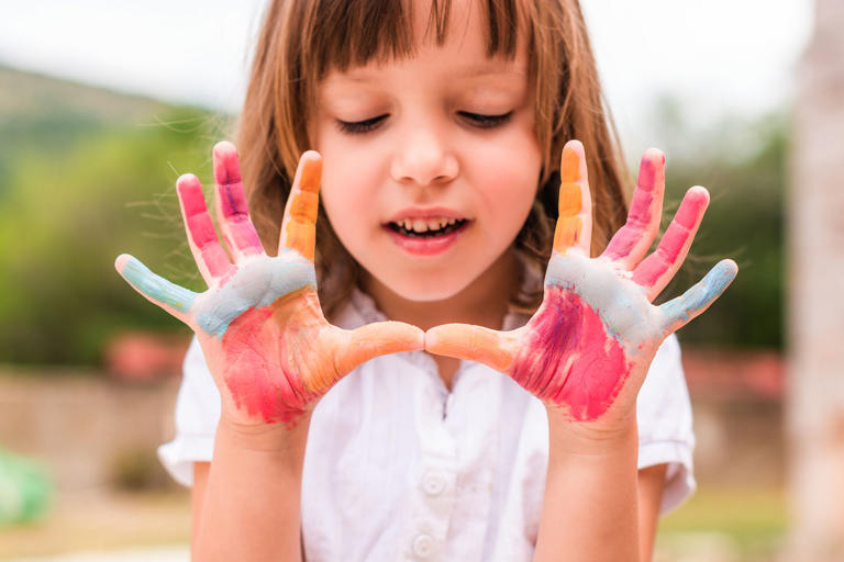Cute little girl with colored hands