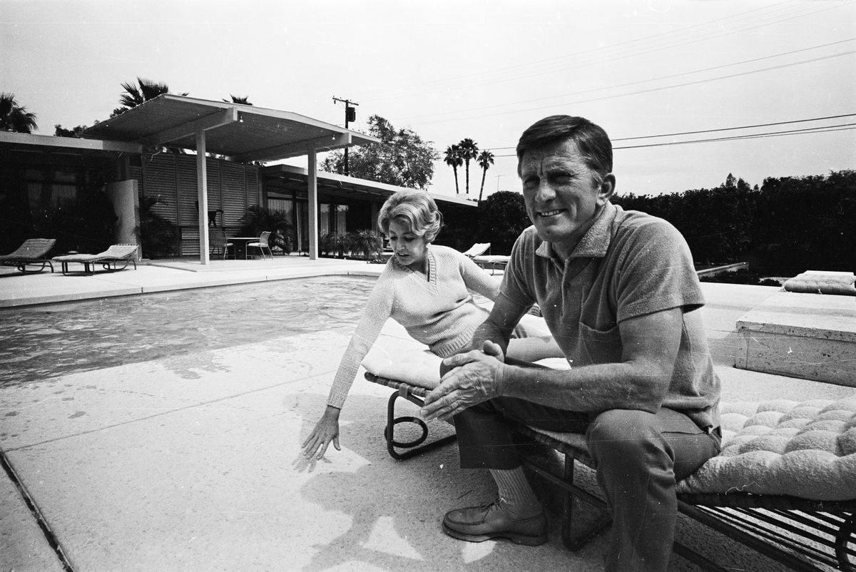 <p>Famous film actor Kirk Douglas was known for his individual tastes in architecture and art. During the early height of his Hollywood career in 1966, Douglas purchased a $17 million home in Beverly Hills. </p> <p>In the above photo, he is pictured alongside his wife Ann, lounging by the pool in the backyard of their grand mansion. </p>
