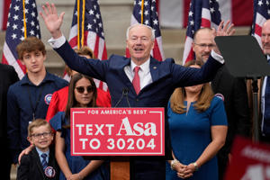 Former Arkansas Gov. Asa Hutchinson is surrounded by family members after formally announcing his Republican campaign for president, Wednesday, April 26, 2023, in Bentonville, Ark.