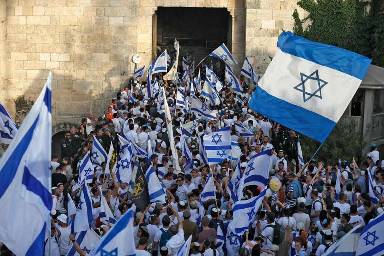 La Marcha de las Banderas atraviesa la Puerta de Damasco en la Ciudad Vieja de Jerusalem.