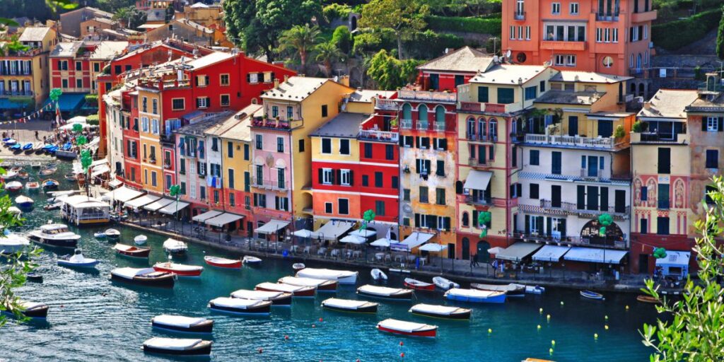 <p><em>Recommended by <a href="https://alexandleahontour.org/" rel="noreferrer noopener">Alex and Leah on Tour</a></em></p> <p>Portofino is an absolutely beautiful village on the Italian Riviera coastline in northern Italy. It's extremely popular with celebrities from all over the world, and once you visit, you'll know why!</p> <p>The best way to get to Portofino is by taking the train from Genoa to Saint Magherita before hopping on a direct bus to the village. The bus trip is an experience; snaking along the cliffside, you'll see magnificent views across the Tyrrhenian Sea. </p> <p>Despite being a small fishing village, there is a lot more to do than meets the eye. Firstly, if you have the budget or just fancy a nose, you definitely need to pop into all the designer shops that line the cobbled street. </p> <p>We'd then recommend going for a wander around the harbor before settling down for an alcoholic beverage, coffee, or even some food. Whilst (obviously) expensive, the food is amazing, and you MUST have an Aperol Spritz! </p> <p>If you're more of an adventurer, you definitely need to hike up to Castelletto or Faro di Portofino as the views are unbelievable. </p> <p>Don't worry if that doesn't appeal to you; you can always sit on the edge of the Marina di Portofino pier and look back at the beautiful, multi-colored buildings of Portofino and watch the world go by.</p> <ul>   <li><a href="https://tp.media/r?marker=330339&trs=144489&p=1922&u=https%3A%2F%2Fwww.viator.com%2Ftours%2FPortofino%2FBest-of-Portofino-Boat-and-Walking-Tour-Pesto-Cooking-and-Lunch%2Fd4232-68388P1" rel="noreferrer noopener nofollow">Portofino Boat and Walking Tour with Pesto Cooking & Lunch</a></li>  </ul>