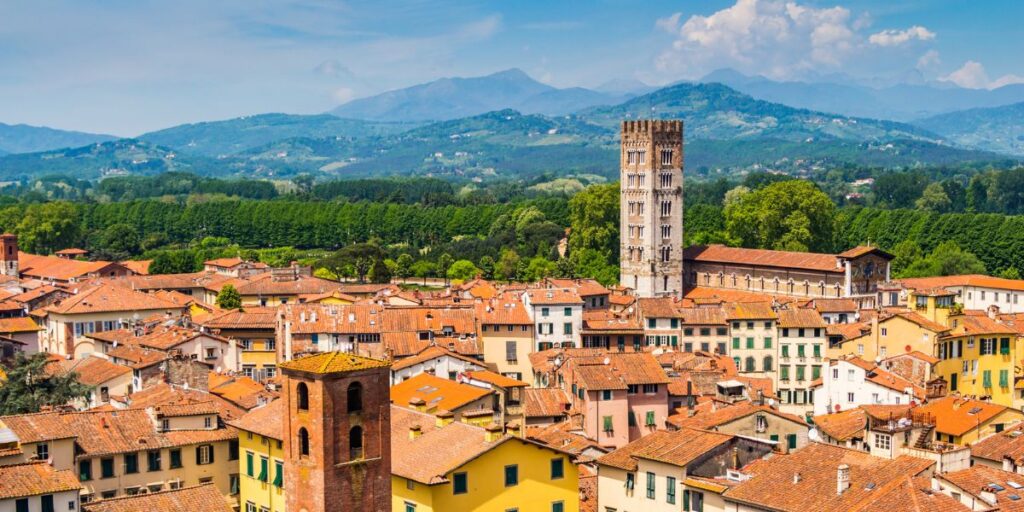 <p><em>Recommended by Chrissy of <a href="https://www.destinedglobetrotter.com/" rel="noreferrer noopener">Destined Globetrotter</a></em></p> <p>Lucca is located on the west coast of Central Italy, near Pisa, and is known as the "City of 100 Churches." Its history includes being founded by the Etruscans and as an important meeting place between Julius Caesar and Crassus (an important Roman general and statesman).</p> <p>During medieval times, a thick wall encircling the town was built. Many European towns did this but eventually tore them down. Lucca's wall still remains and is a popular walking spot. The piazza is built on the site of a Roman amphitheater, as evidenced by its shape still today.</p> <p>The Cattedrale di San Marino (Duomo) was constructed from the 11<sup>th</sup> to 14<sup>th</sup> centuries. The series of archways draws your eyes to the façade and the unfinished bell tower next door. This tower has become an icon of the city because of the garden of olive trees that sit atop the tower. Visitors that climb to the top are rewarded with great city views.</p> <p>This small museum is in the house where Puccini was born. It houses his piano as well as some of his original opera scores and costumes. This aqueduct once carried mountain water to the city. There are 400 stone arches that you can follow from the Temple Cistern to Paraco dell'Acquedotto.</p>