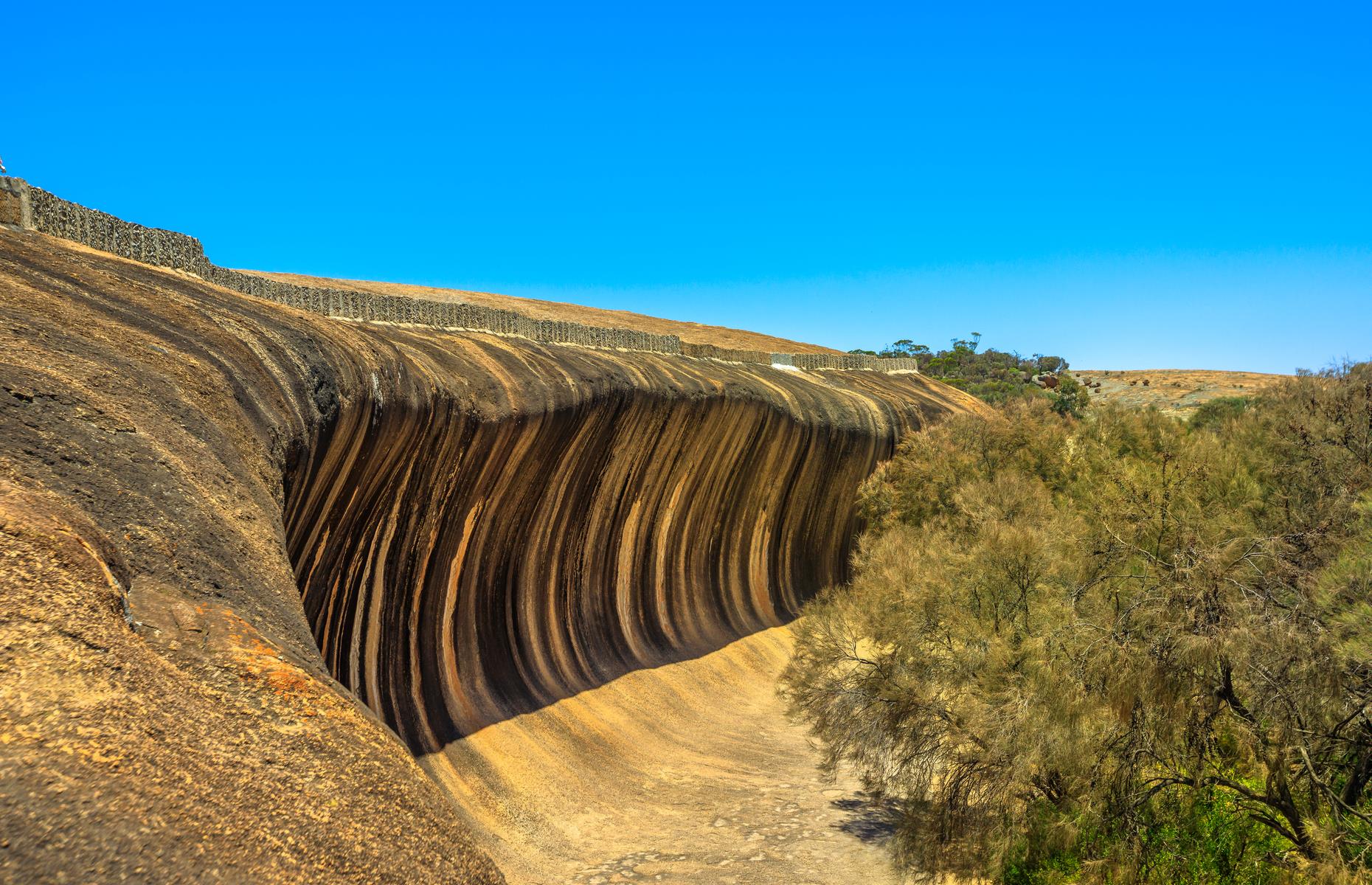 Australia is known for its big waves but you’ll find one of its most spectacular far away from the ocean – a four-hour drive east of Perth. The striking granite cliff known as Wave Rock rises 15m (49ft) above the outback plain in Western Australia’s Golden Outback region. The ancient rock formation is particularly spectacular from September to November when wildflowers carpet the region.