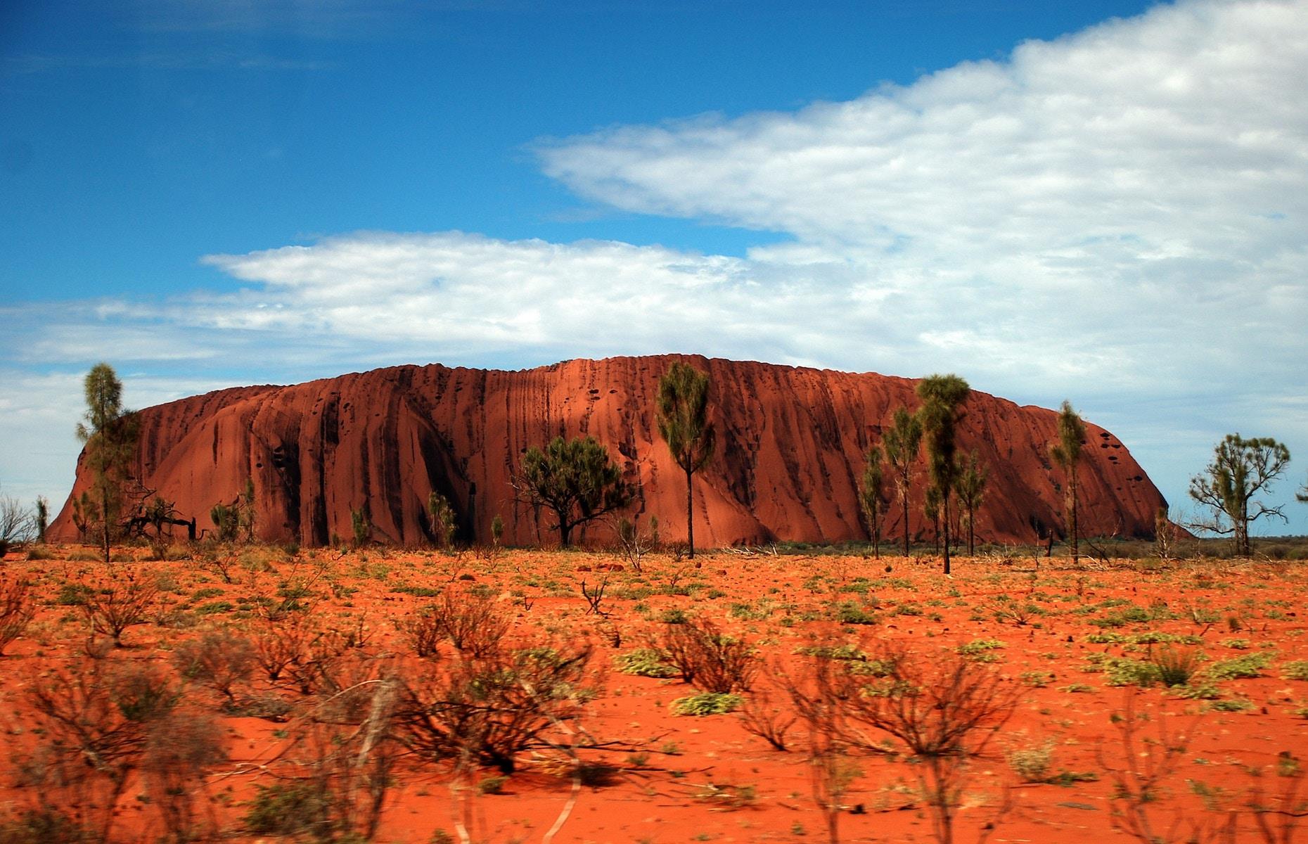 The imposing beauty and spiritual significance of this mammoth monolith, which thrusts out of the red dirt in the desolate center of Australia, is unnerving. Surrounded by the Red Centre's untamed wilderness as far as the eye can see, there's something truly primeval about the ancient sandstone boulder. It's a hugely sacred site for the Anangu people – the custodians of the land – and one of the greatest natural wonders of the world.