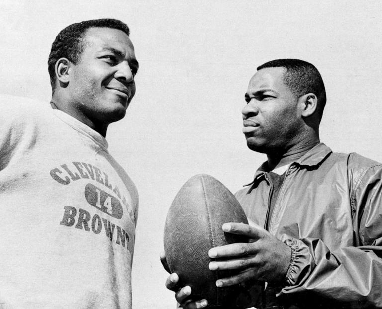 In this Jan. 11, 1964, file photo, fullback Jim Brown, left, and flanker back Bobby Mitchell, once a feared duo for the Cleveland Browns before Mitchell was dealt to Washington, as they prepare for the Pro Bowl at Los Angeles.