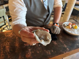 Jeremy Benson holds up a Blue Point oyster from the waters off Connecticut. Benson is general manager of Crave Fish Bar in New York, which does a brisk business in oysters from the East and West coasts.