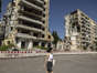 A woman crosses a parking lot near a partly destroyed high-rise building in Dnipro, Ukraine on June 1.