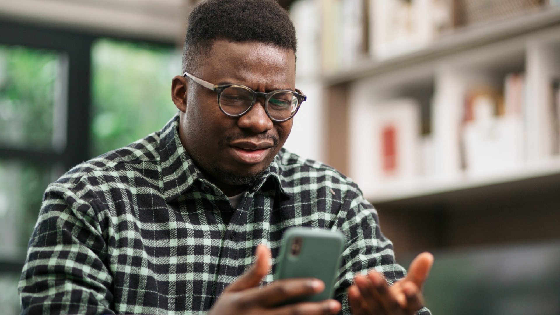 man glasses upset angry confused smartphone_iStock-1289427419